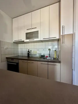 Manja kuhinja sa belim i bež elementima, ugrađenom rernom i sudoperom. - image 6