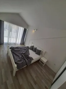 Svjetla spavaća soba sa bijelim krevetom i velikim prozorom. - image 3