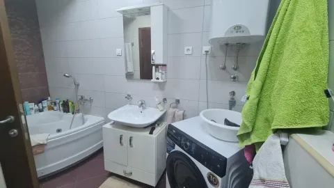 Kupatilo opremljeno kadom, umivaonikom, ogledalom i veš mašinom. - image 6