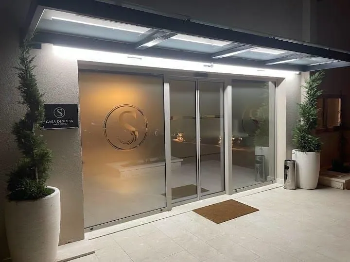 Main entrance of the building with glass doors and decorative lighting.