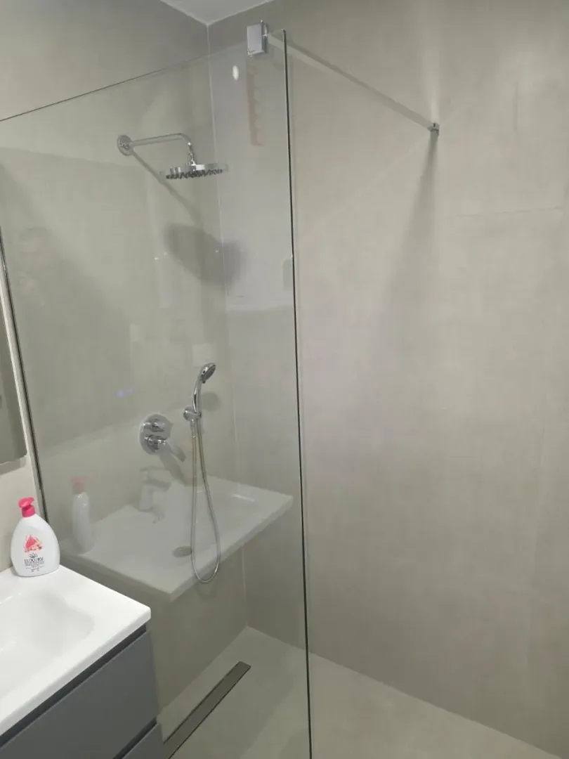 Moderne opremljeno kupatilo sa tuš kabinom i umivaonikom.