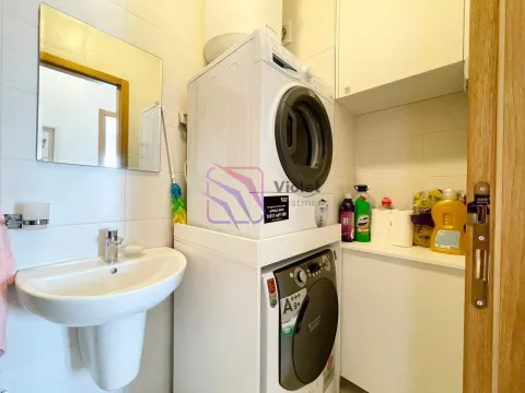 Bathroom with a sink and stacked washer and dryer units. - image 8