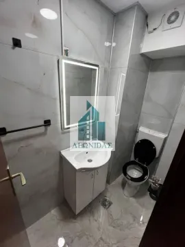 Modernly equipped bathroom with a washbasin, illuminated mirror, and toilet. - image 15