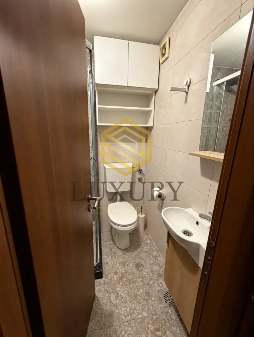 Smaller bathroom with a toilet, washbasin, and shower cabin.