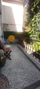 Natkrivena terasa sa metalnom ogradom i pogledom na dvorište. - image 15