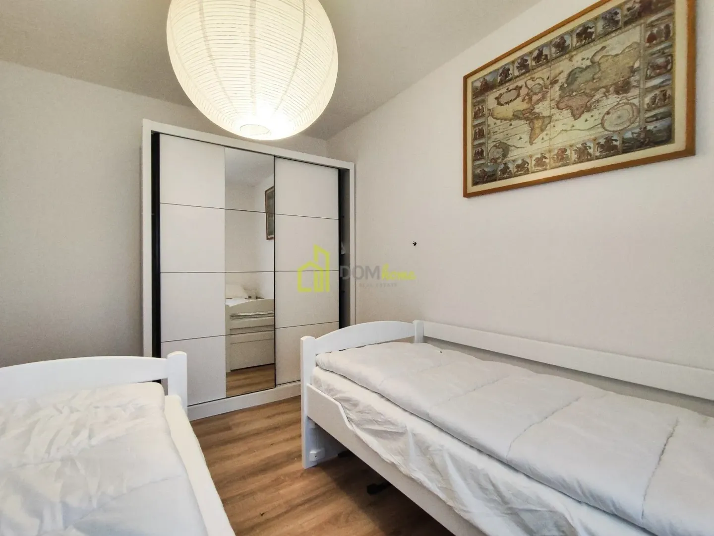 Bedroom with two beds and a wardrobe.