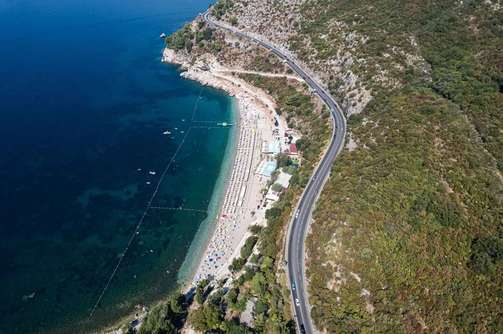 Pogled iz vazduha na obalu, magistralni put i plažu sa morem.