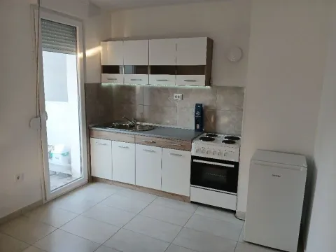 Small bright kitchen with white cabinets and a stove. - image 5