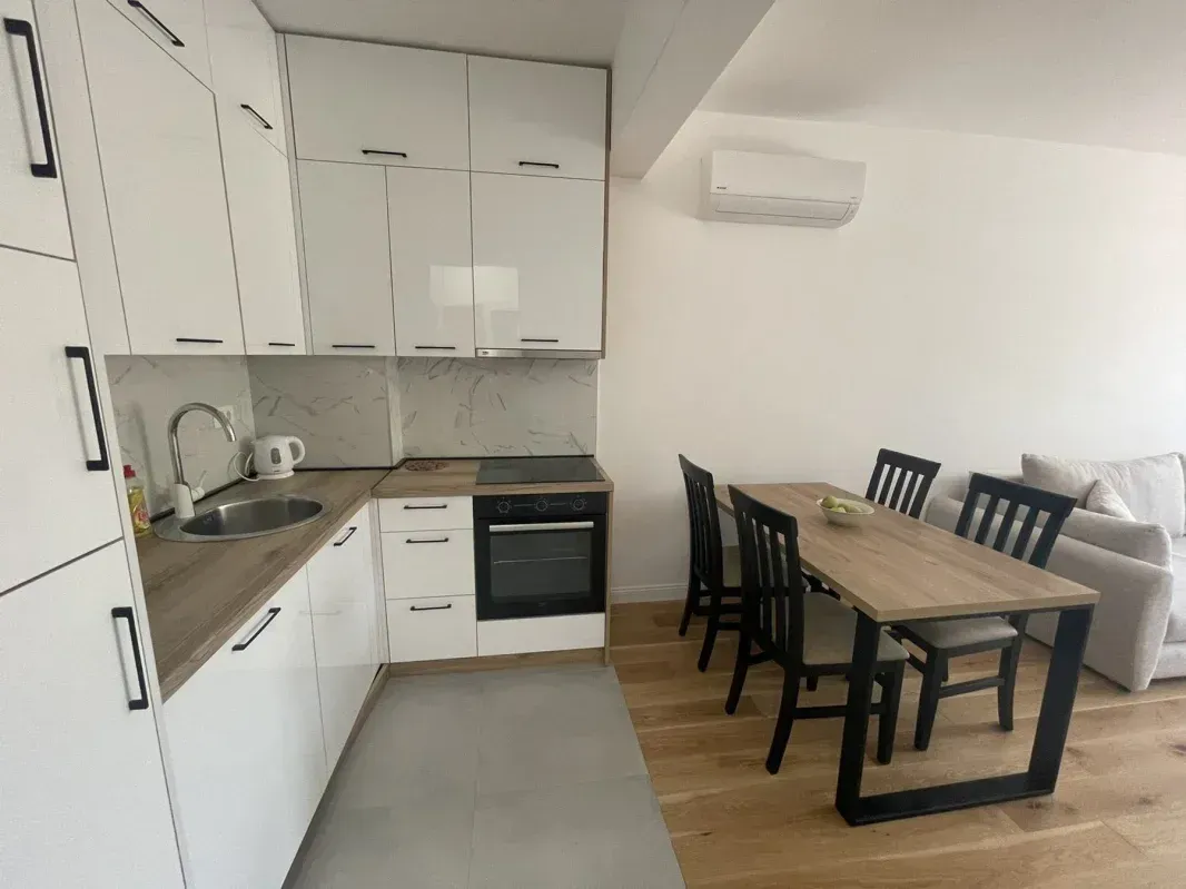 Modern kitchen with a dining area and living room in bright tones.