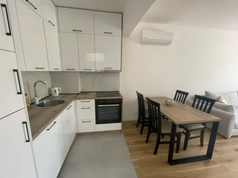 Modern kitchen with a dining area and living room in bright tones. - image 2