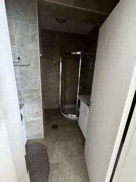 Pogled na kupatilo sa tuš kabinom kroz otvoren ulaz. - image 4