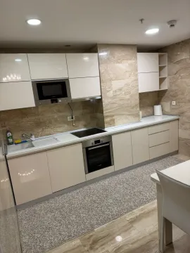 Modern kitchen with built-in appliances and glossy white cabinets. - image 20