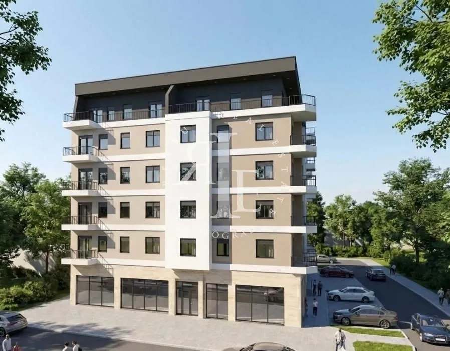 Spoljašnji izgled moderne stambene zgrade sa terasama i parkingom u okruženju.