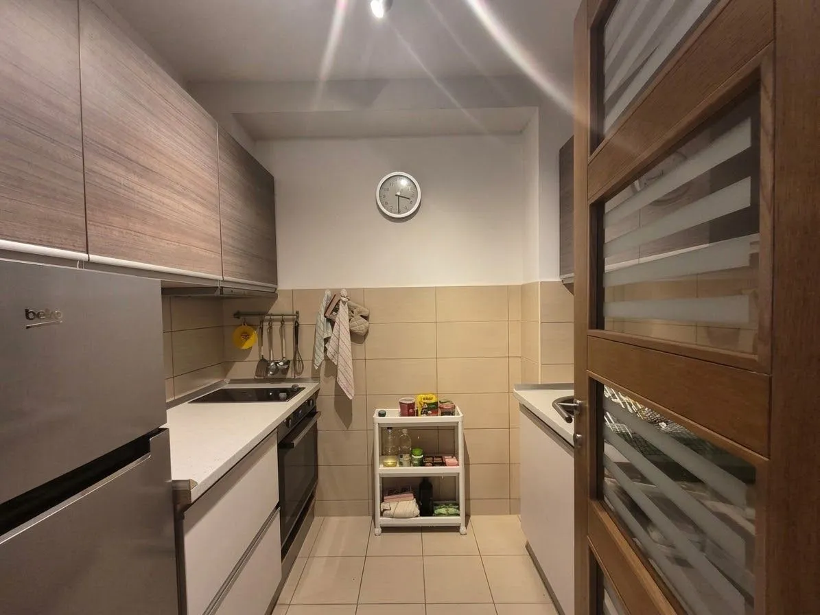 Small kitchen with wooden cabinets and built-in appliances.