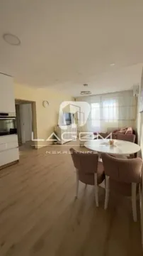 Dnevni boravak sa trpezarijom i delom kuhinje u svetlim tonovima. - image 2