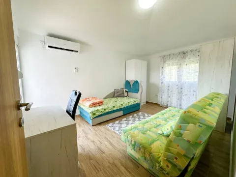 Namještena spavaća soba sa krevetom, radnim stolom i klima uređajem. - image 10