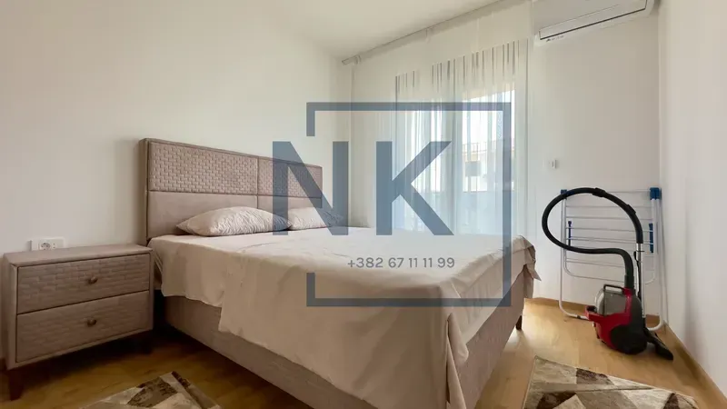 Bedroom with a double bed, bedside table, and access to the terrace.