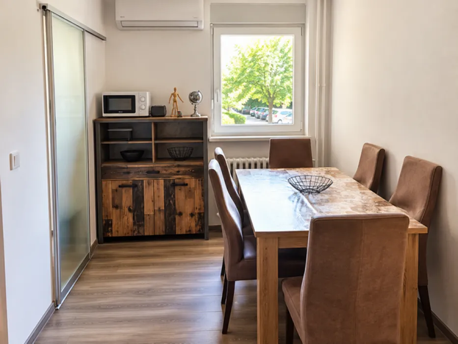 Dining area with a wooden table, chairs, and a sideboard.