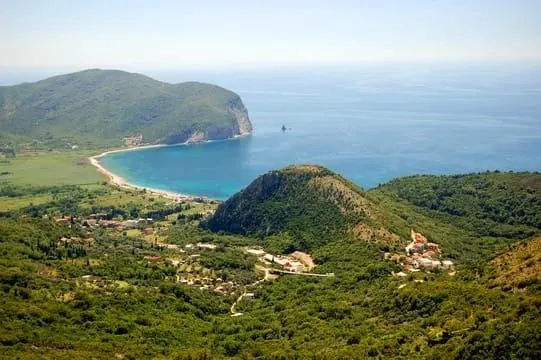 Pogled iz vazduha na uvalu i brdoviti pejzaž sa morem u pozadini.