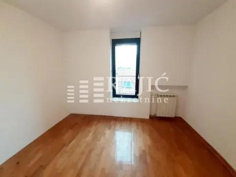 Empty room with wooden flooring and a single window. - image 13