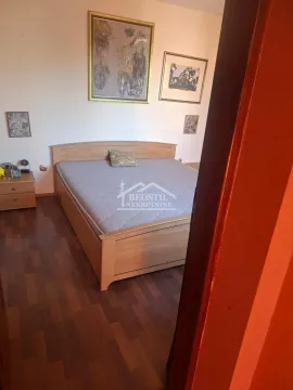 Bedroom with a double bed, bedside table, and paintings on the wall. - image 7