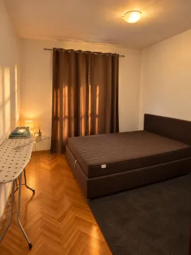 Bedroom with a double bed, parquet flooring, and brown curtains. - image 3