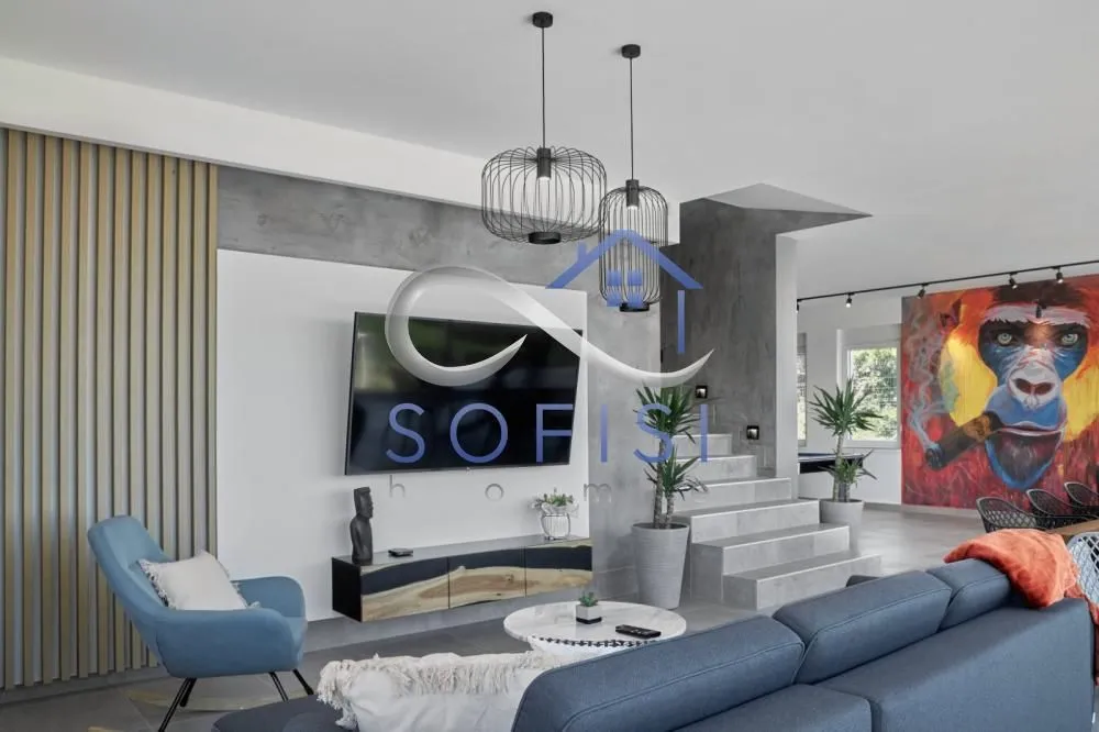 Modern living room with a sofa, television, and decorative elements.
