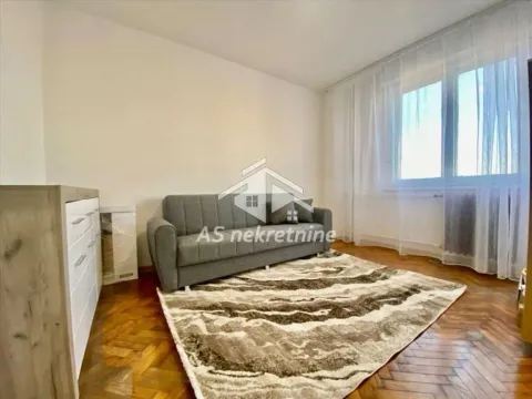 Living room with a grey sofa, carpet, and parquet flooring. - image 5