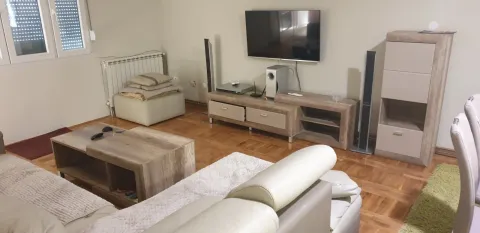 Bright living room with a leather sofa and TV. - image 17
