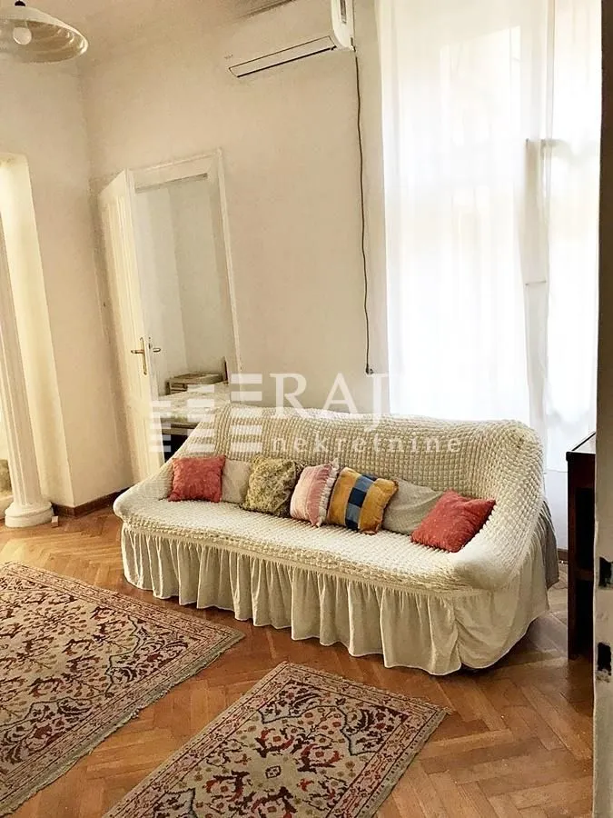 Living room with a sofa and parquet flooring.