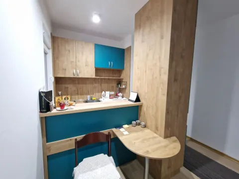 Small kitchen with wooden elements and a breakfast bar. - image 8