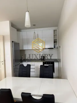 Modern kitchen with white cabinetry and a dining table in the foreground. - image 4