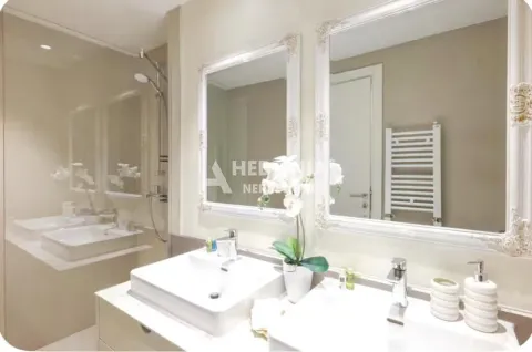 Modern bathroom with two sinks and large mirrors with decorative frames. - image 9