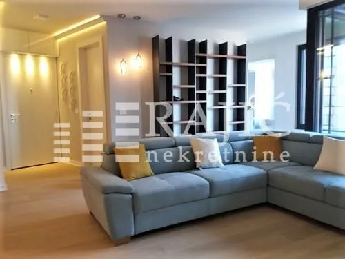 Living room with a large sectional sofa and a modern bookshelf.