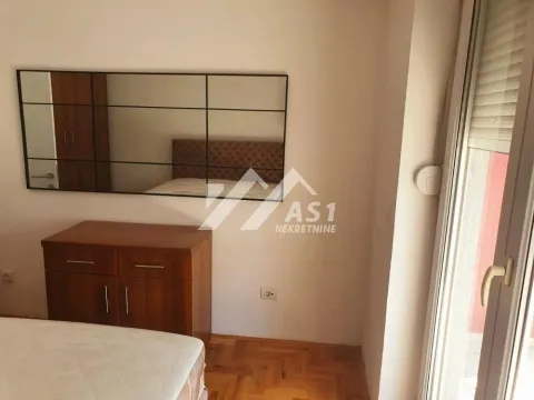 Pogled na spavaću sobu sa krevetom, komodom i ogledalom. - image 6