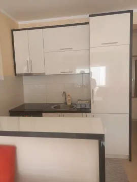 Moderna bijela kuhinja sa šankom i ugradnom pločom. - image 9