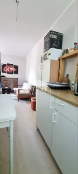 Dnevni boravak povezan sa kuhinjom u stanu. - image 2