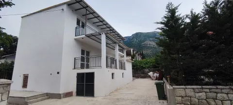View of the exterior of a white two-story house with terraces and a yard. - image 3