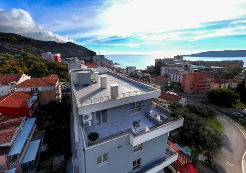 Pogled iz vazduha na višespratnu zgradu i okolno naselje sa pogledom na more. - image 10