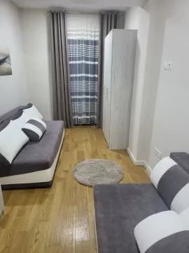 Bright room with two sofas, wooden flooring, and a white wardrobe. - image 14
