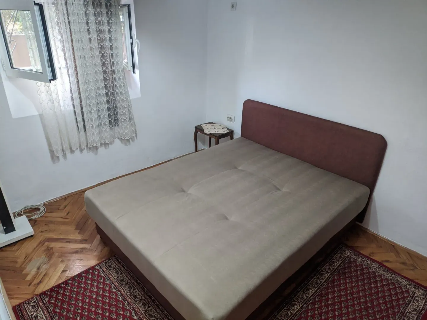 A simply furnished bedroom with a double bed.