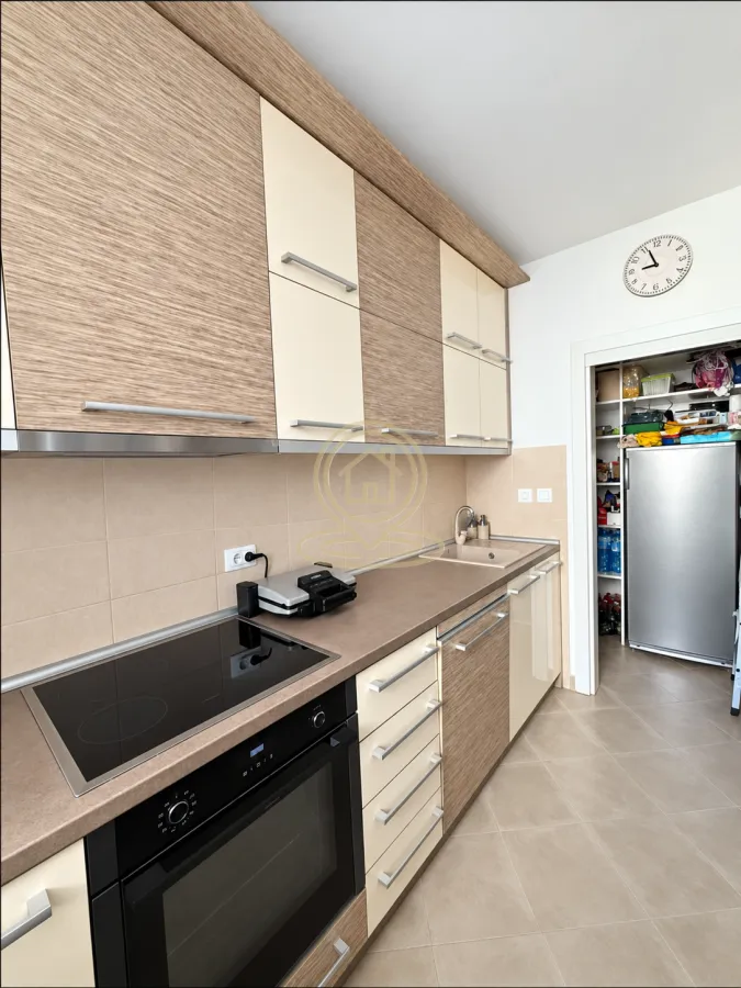 Kitchen with wooden cabinetry, built-in oven and hob.