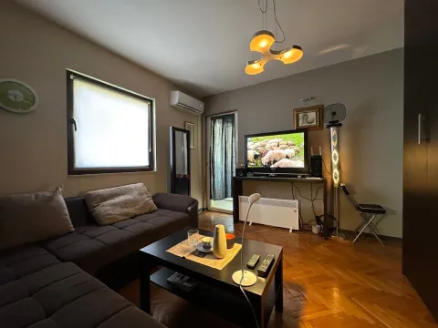 Furnished living room with a sofa, coffee table, and television. - image 2
