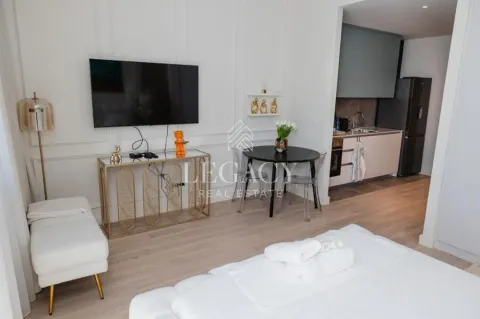 Moderna spavaća soba sa TV-om, trpezarijskim stolom i pogledom na kuhinju. - image 8