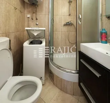 Compactly equipped bathroom with a shower cabin, washbasin, and washing machine. - image 9