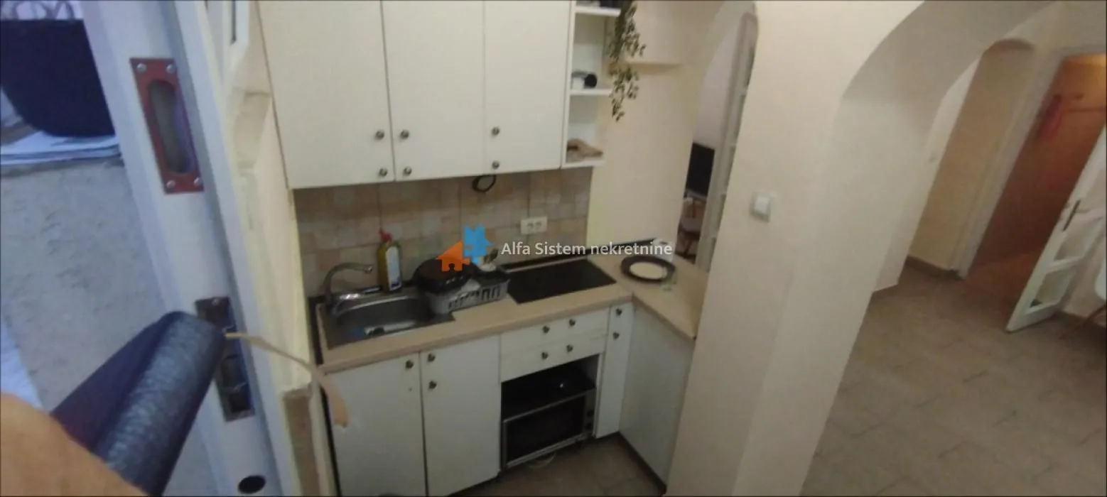 Small kitchen with white units and a sink.
