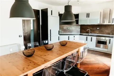 Bright and modern kitchen with a large dining table. - image 4