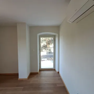 Empty room with wooden flooring, air conditioning unit and a door leading outside. - image 28