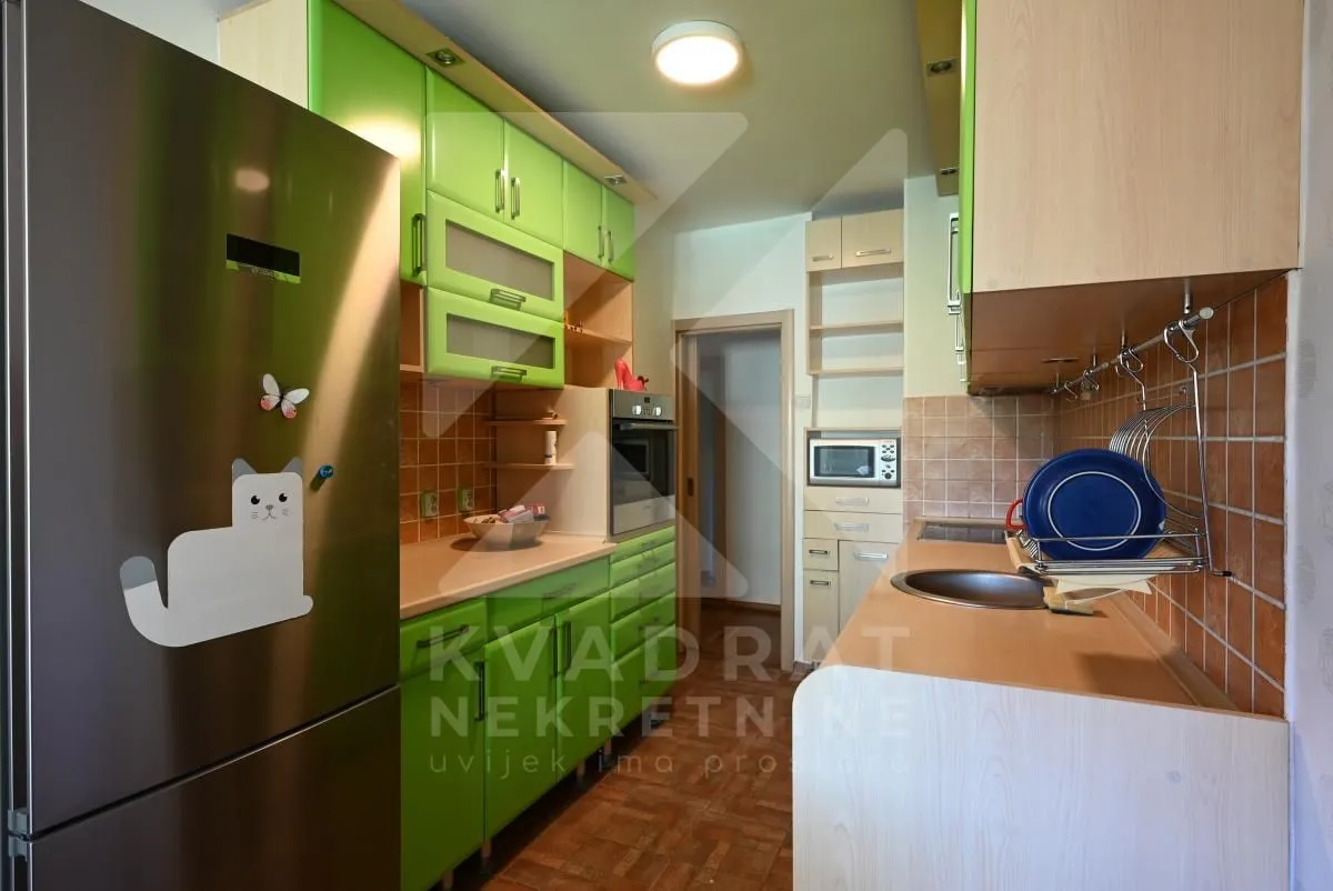 Kitchen with green cabinets and built-in appliances.