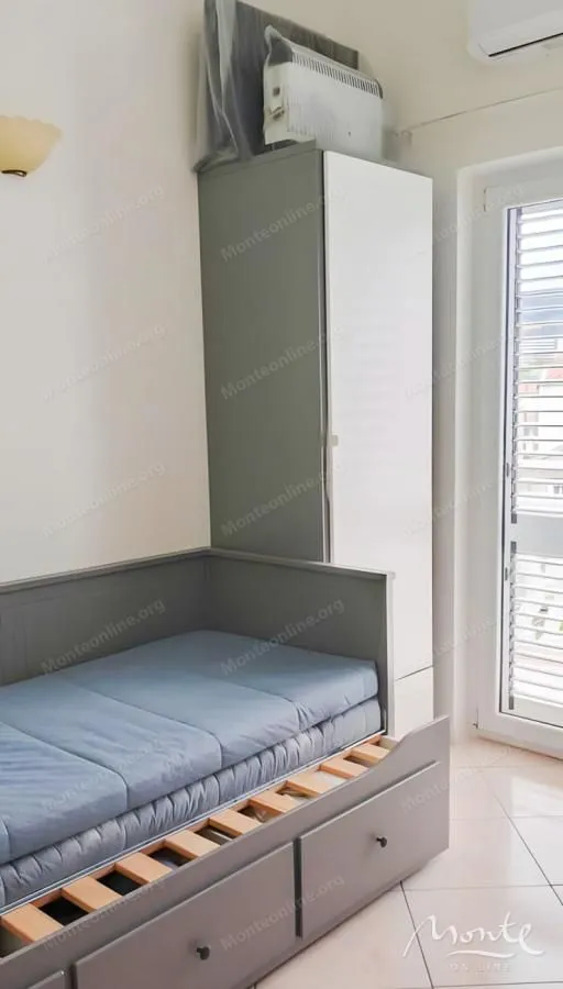 Manja spavaća soba sa krevetom na izvlačenje i garderoberom.